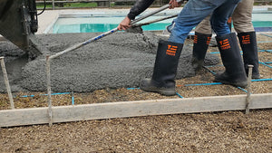 Workers wear TREDS Concrete Boots while pouring concrete